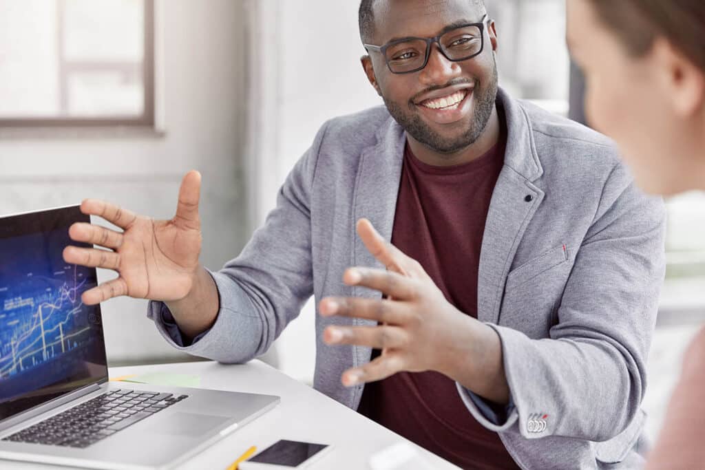 Skilled professional with cheerful expression makes speech during meeting